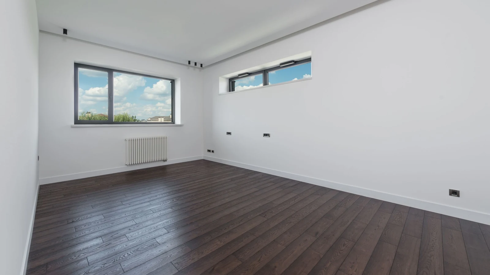 Pièce vide et lumineuse au parquet sombre fraîchement posé